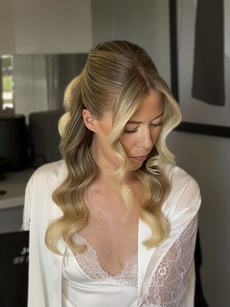 Bride in her robe with half-up Hollywood waves